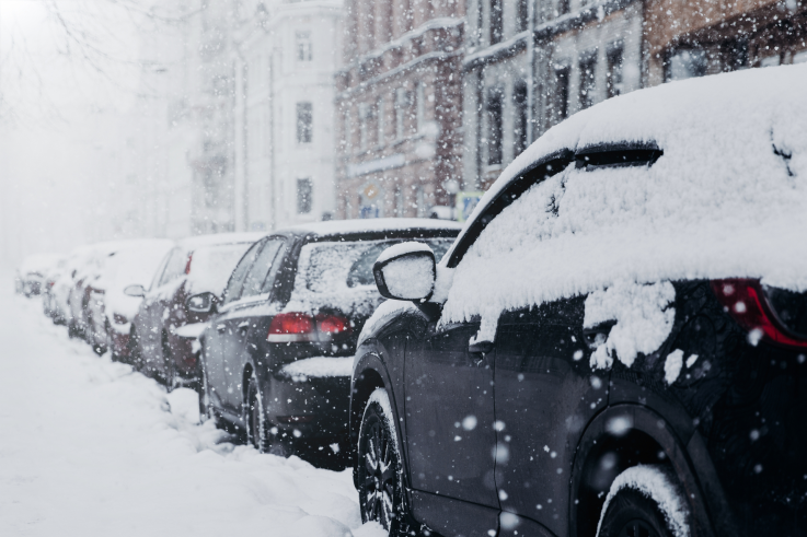 cars parked on side of street snow covered cars