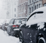 cars parked on side of street snow covered cars